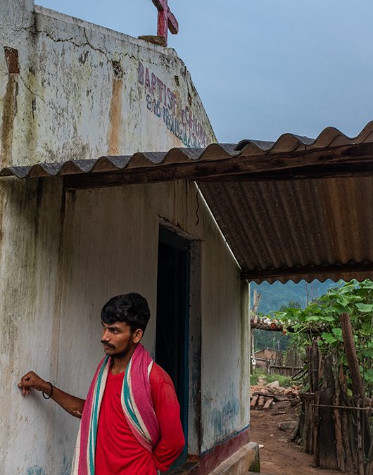 A man leans against the wall of a church that was rebuilt after being destroyed by Hindu nationalists during the 2008 Kandhamal riots. Kandhamal, Odisha, India. 2018. Photo: John Fredricks